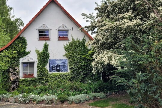 Ein weißes Haus mit grünem Bewuchs